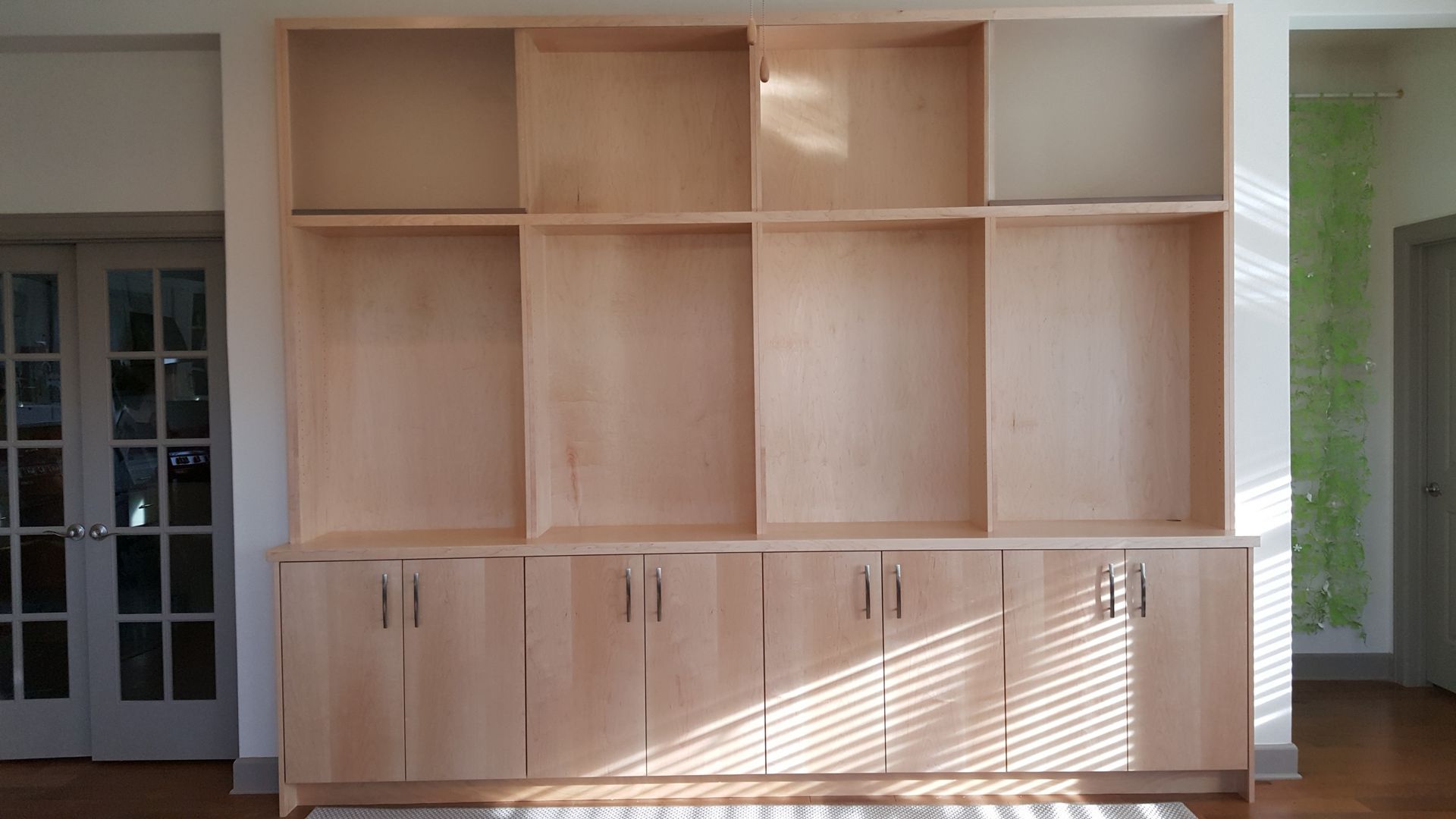A large wooden bookcase with lots of shelves and doors