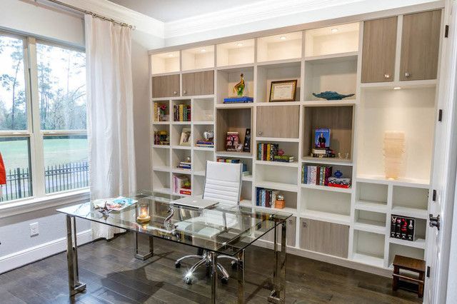 A home office with a glass desk , chair , and shelves.