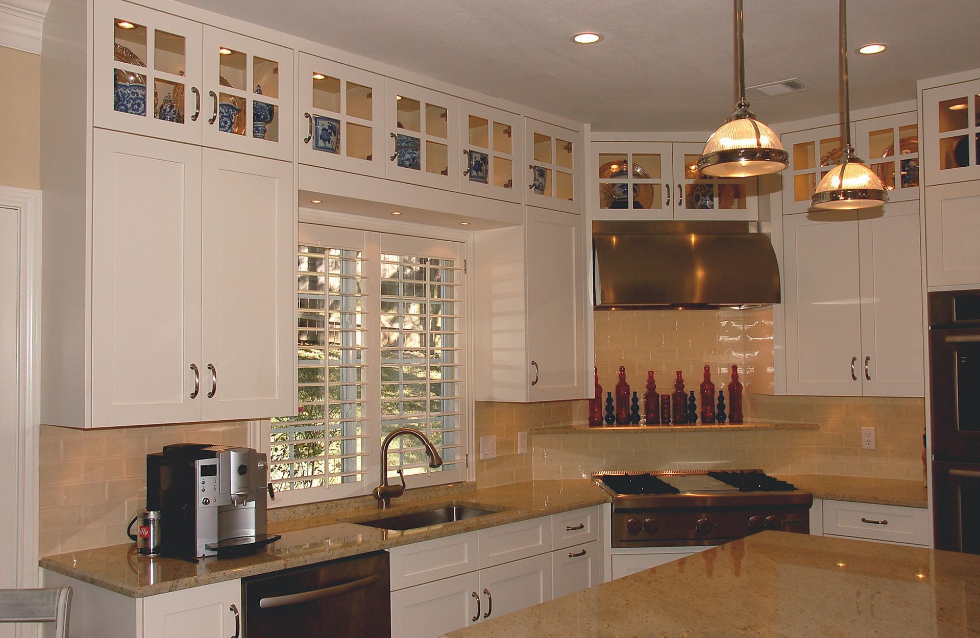 A kitchen with white cabinets and granite counter tops