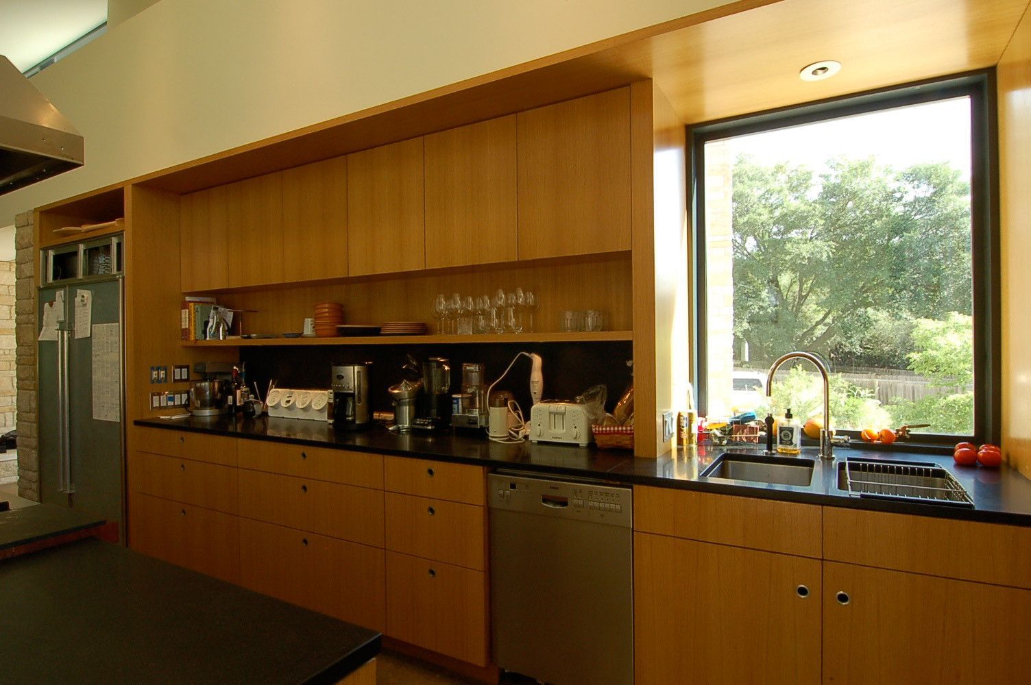 A kitchen with wooden cabinets and a large window