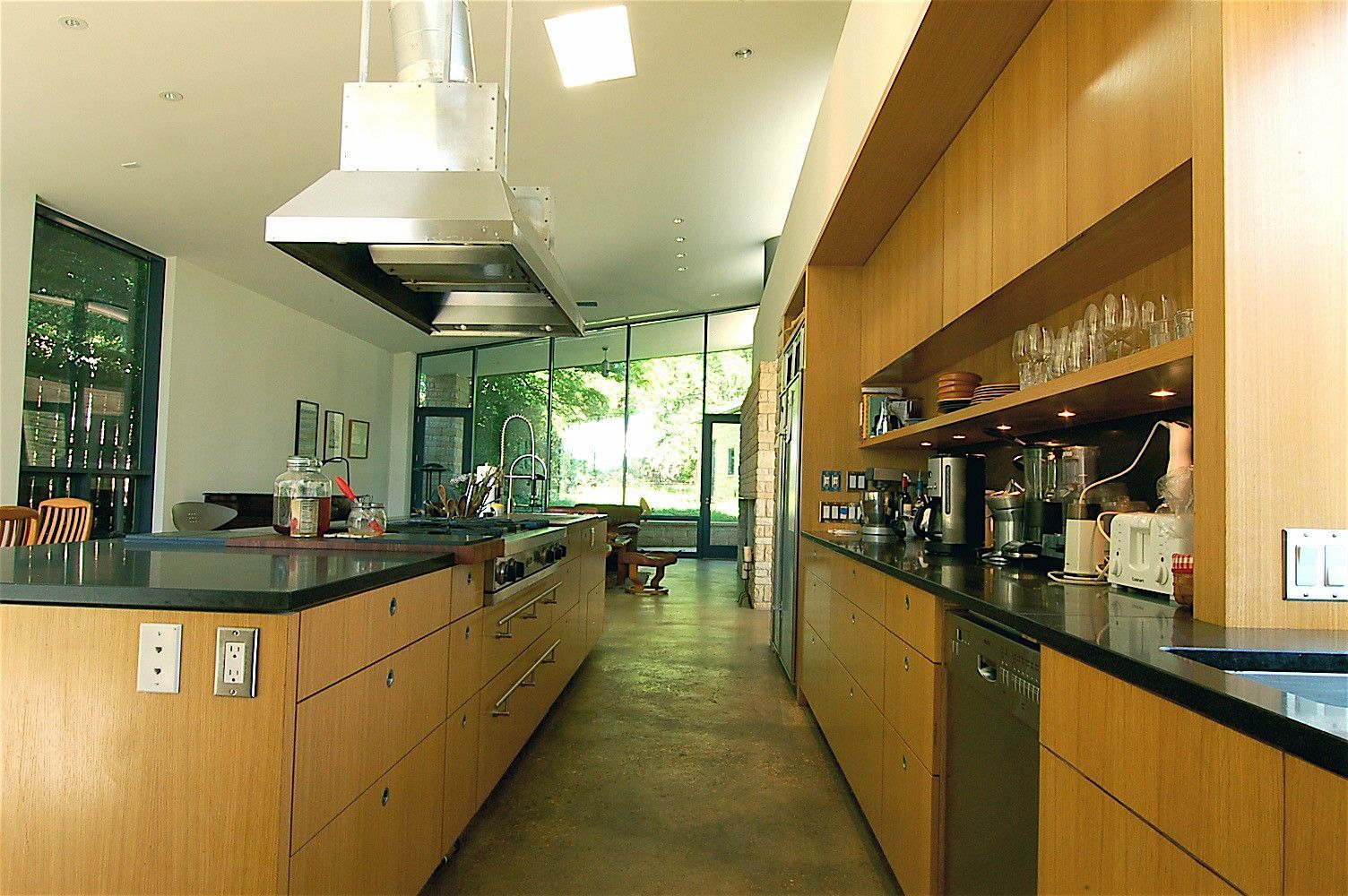 A kitchen with wooden cabinets and black counter tops