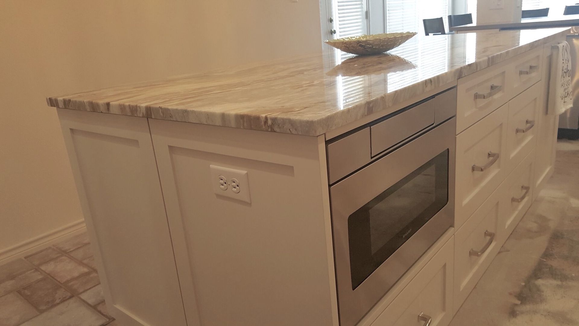 A kitchen with a large island and a microwave oven.