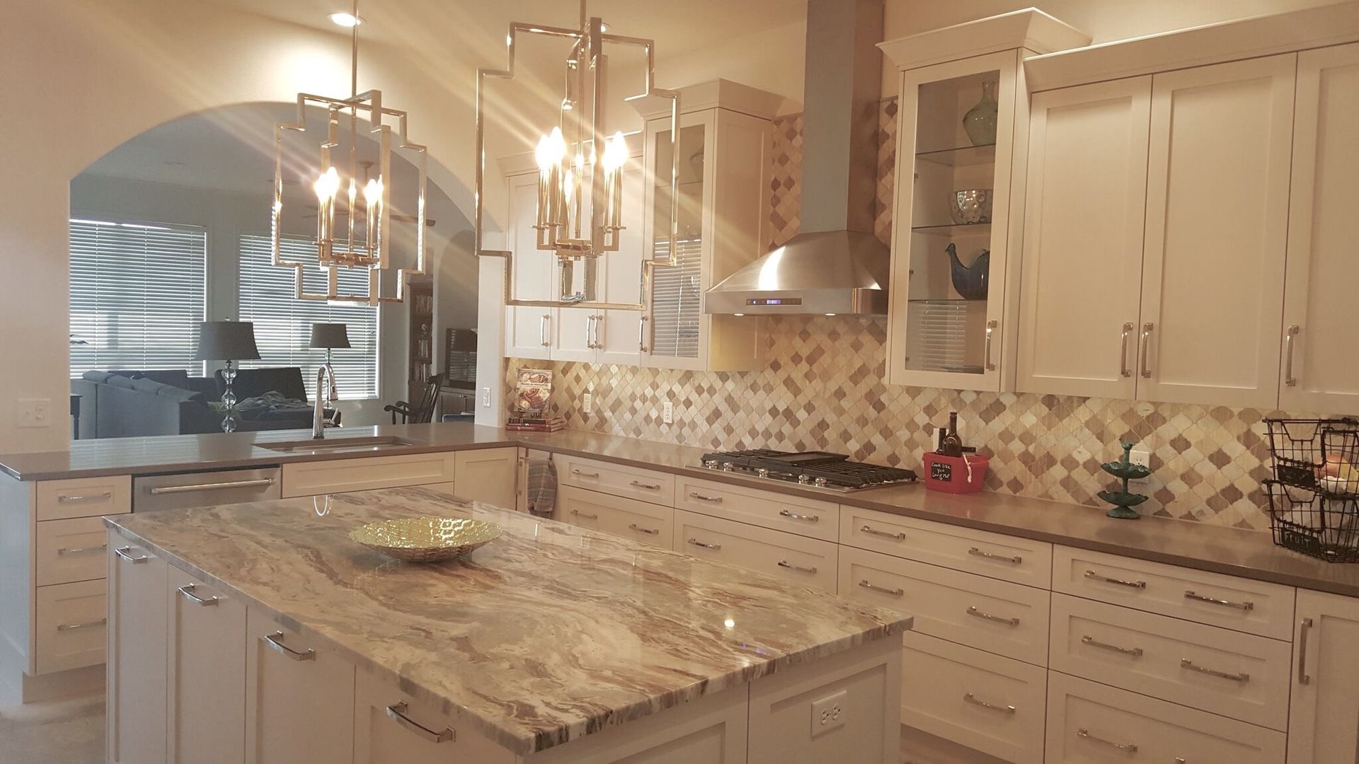 A kitchen with white cabinets and granite counter tops.