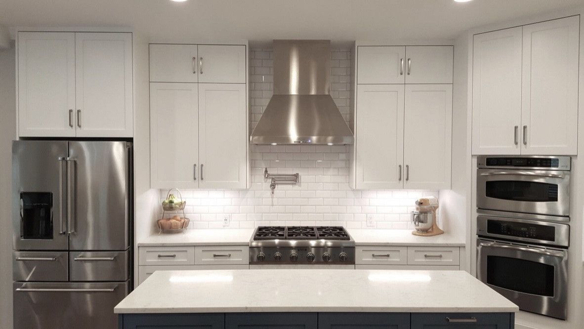 A kitchen with stainless steel appliances and white cabinets.