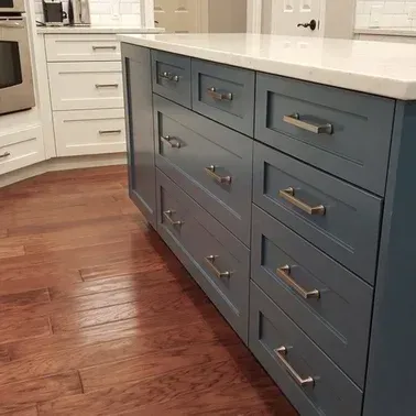 A kitchen with blue cabinets and a white counter top.