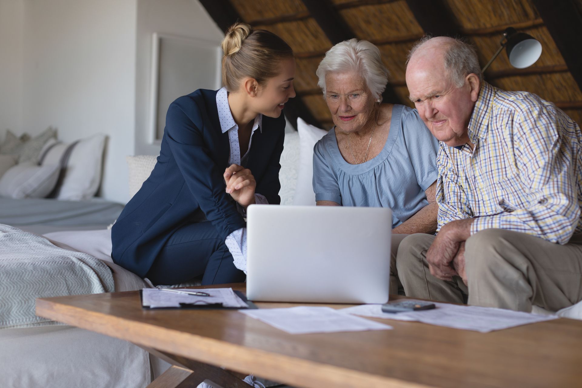 Woman showing a laptop to an elderly couple, reviewing elder law planning.