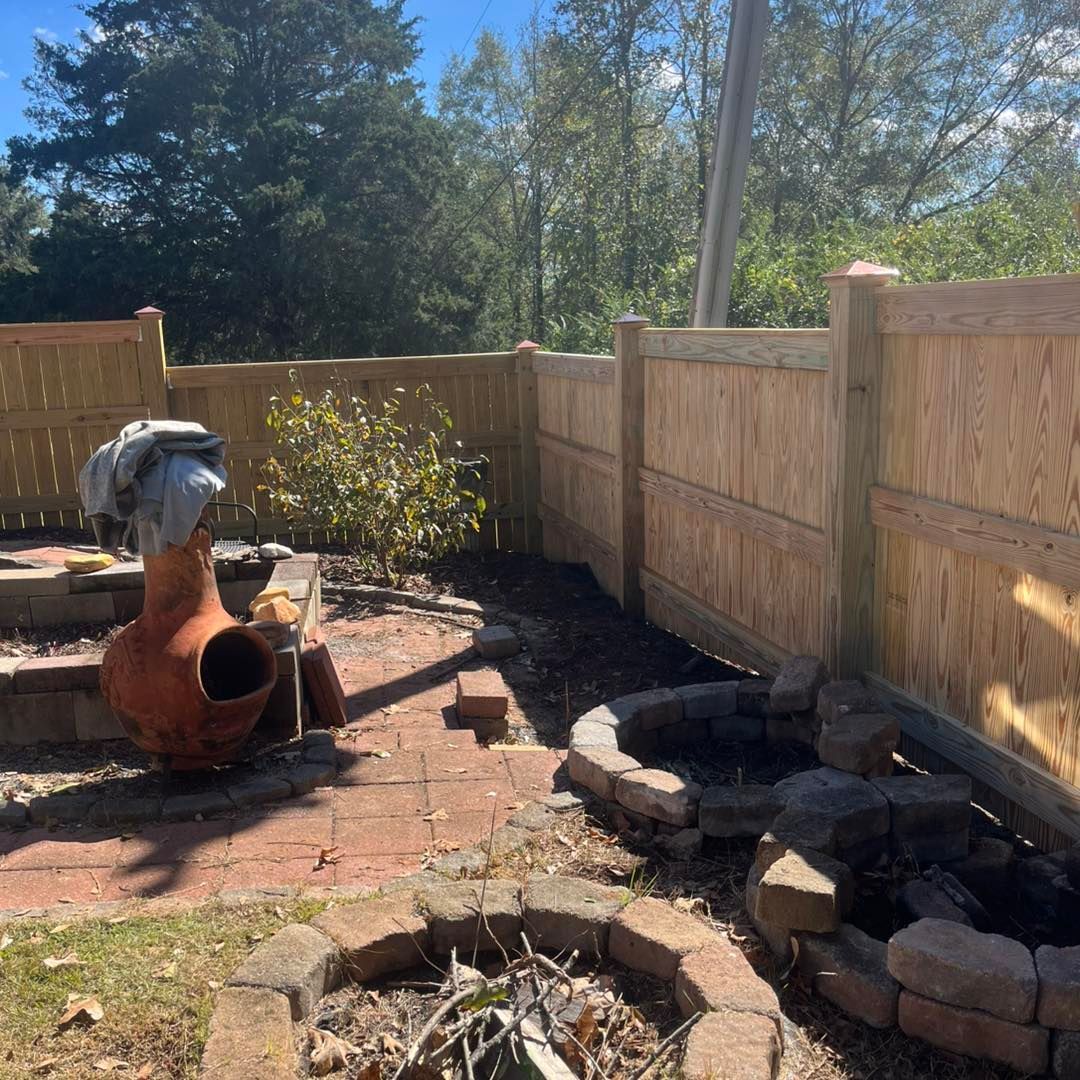 Backyard with brick patio, fire pit, clay chiminea, wooden fence, and trees.