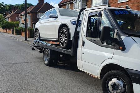 White car on a pick-up van