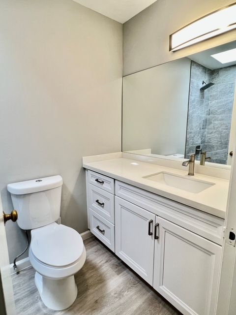 A bathroom with a toilet , sink and mirror