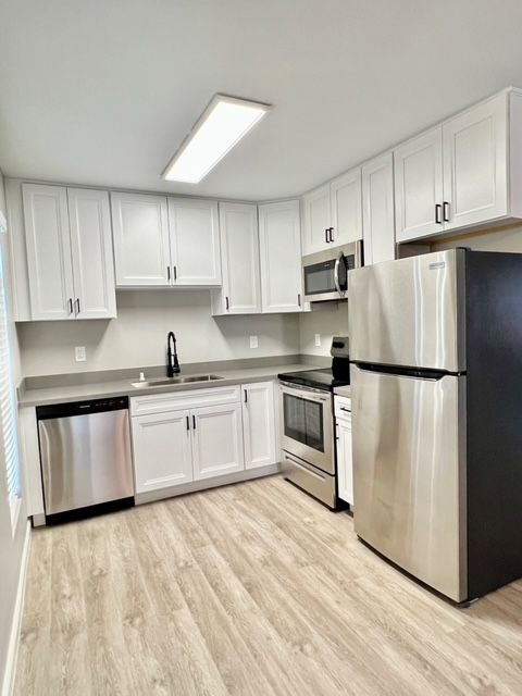 A kitchen with stainless steel appliances and white cabinets