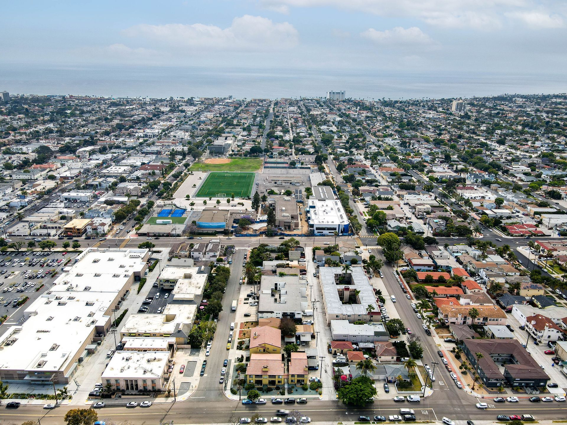 An aerial view of a city with a baseball field in the middle of it.