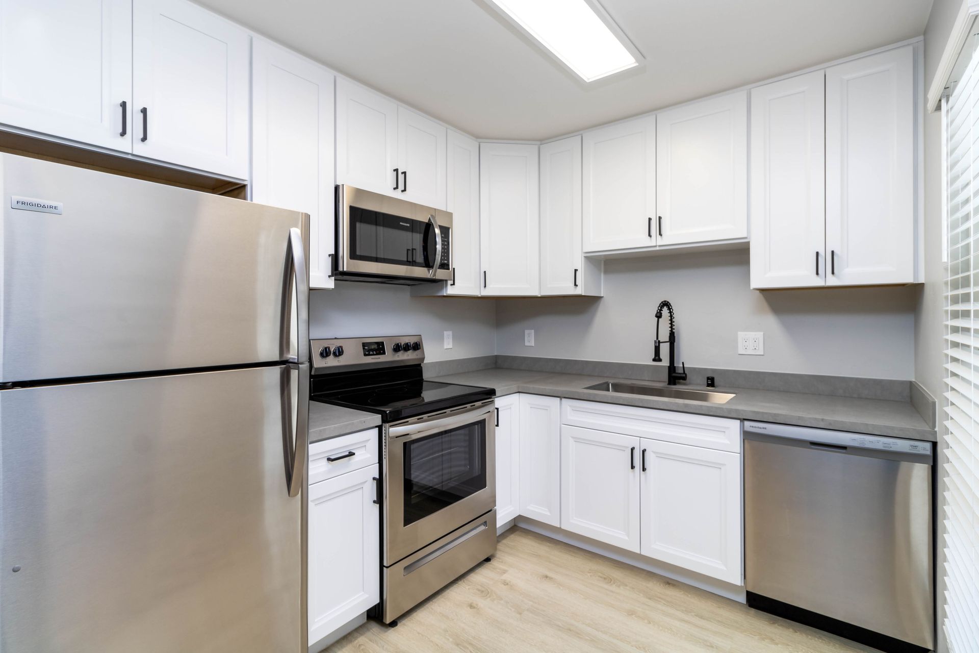 A kitchen with stainless steel appliances and white cabinets.