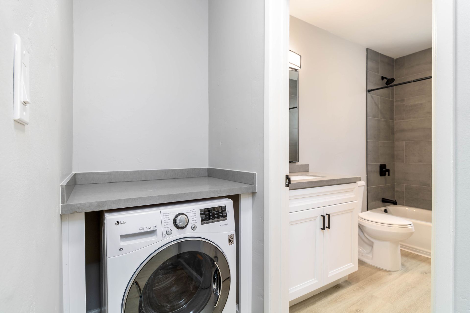 A laundry room with a washer and dryer next to a bathroom.