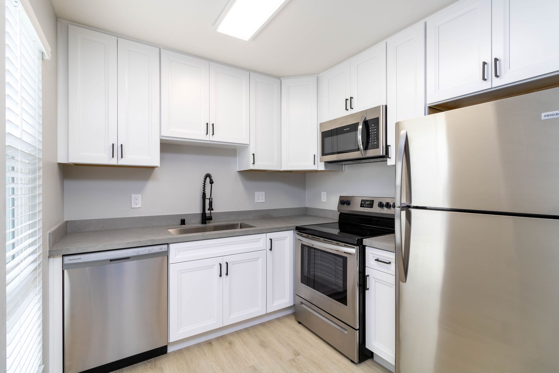 A kitchen with stainless steel appliances and white cabinets
