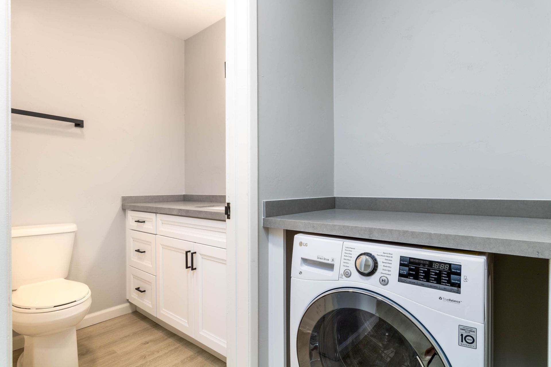 A laundry room with a toilet , washer and dryer.