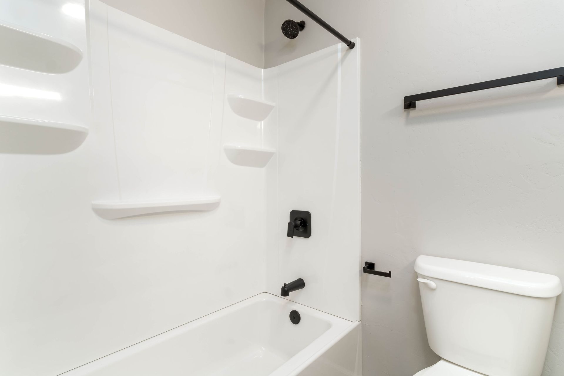 A bathroom with a toilet , bathtub and shower.