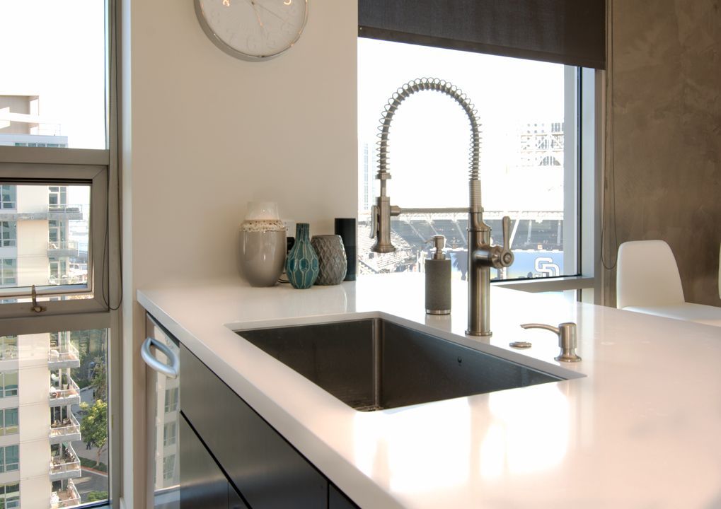 A kitchen with a sink and a clock on the wall