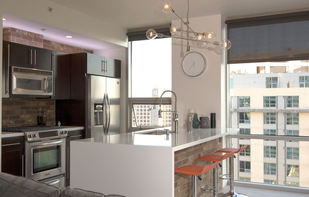 A kitchen with stainless steel appliances and a clock on the wall