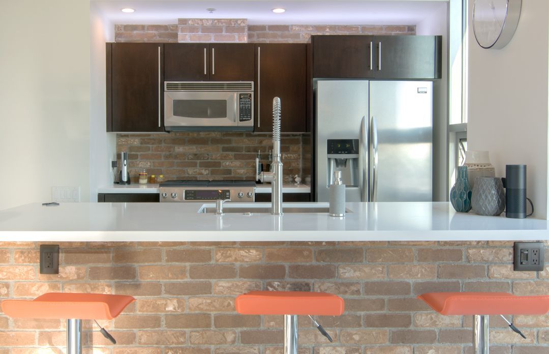 A kitchen with a refrigerator , sink , and microwave