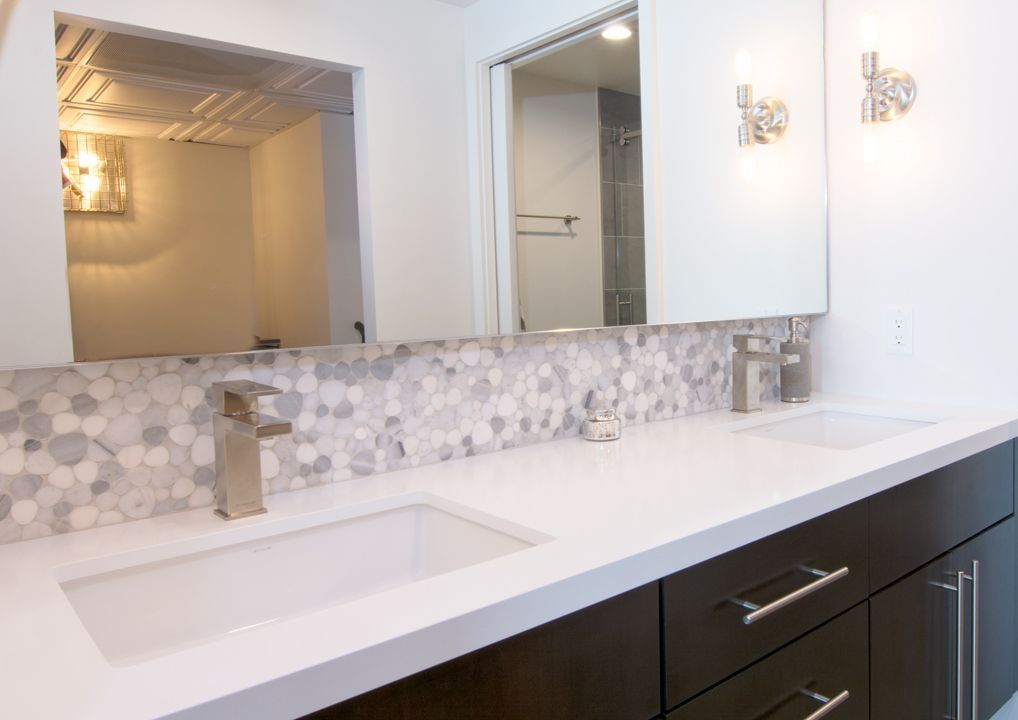 A bathroom with two sinks and a large mirror.