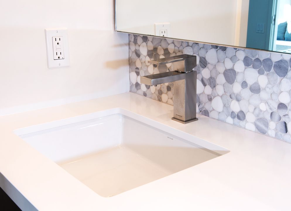 A bathroom sink with a faucet and a mirror.