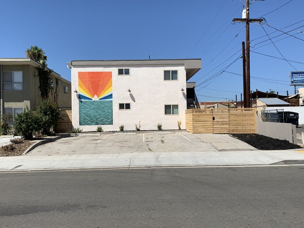 A white building with a large mural on the side of it