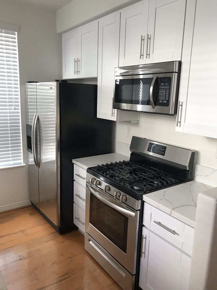 A kitchen with a stove , refrigerator , microwave and stainless steel appliances.