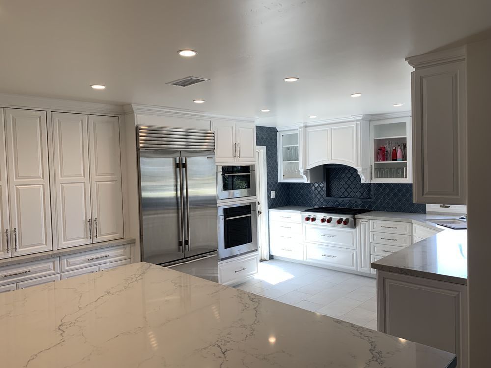 A kitchen with white cabinets and stainless steel appliances.