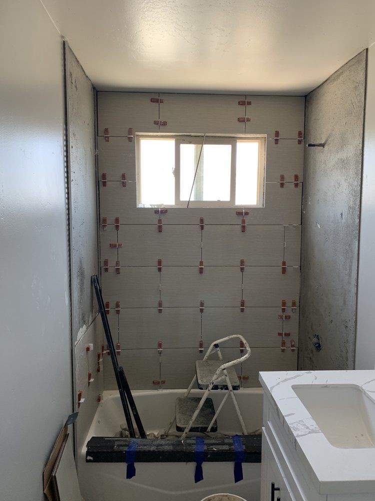 A bathroom with a bathtub , sink , and window.