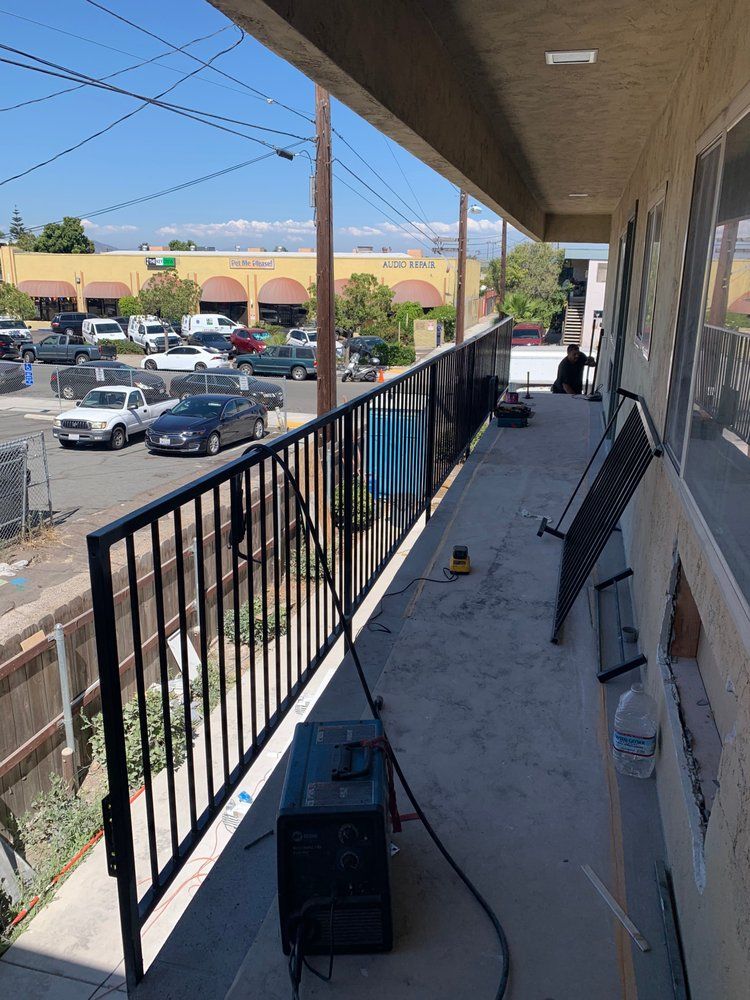 A balcony with a welding machine on it is being built on the side of a building.