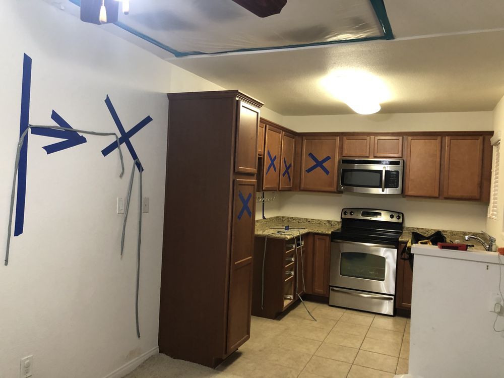 A kitchen with wooden cabinets and a stove and microwave