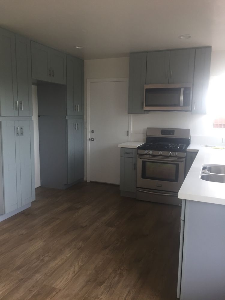 A kitchen with a stove , microwave , refrigerator and sink.