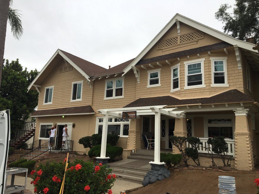 A large house with a white pergola on the front porch