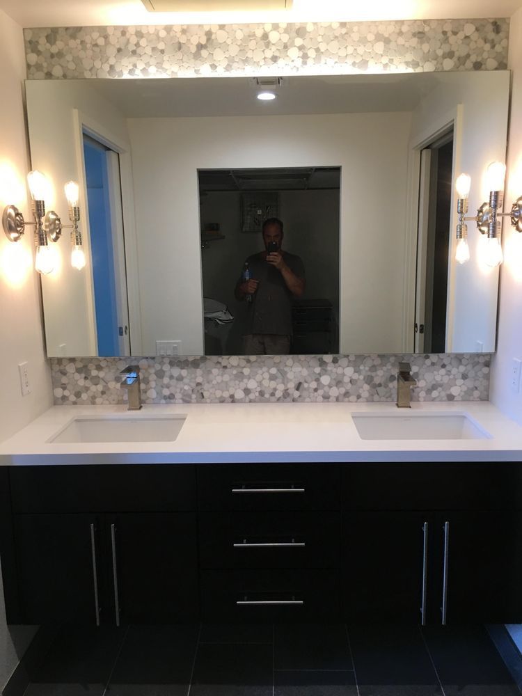 A man is taking a picture of himself in a bathroom mirror.