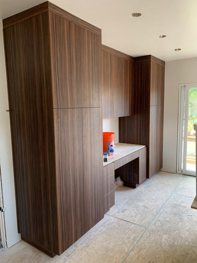 A kitchen with wooden cabinets and a desk.