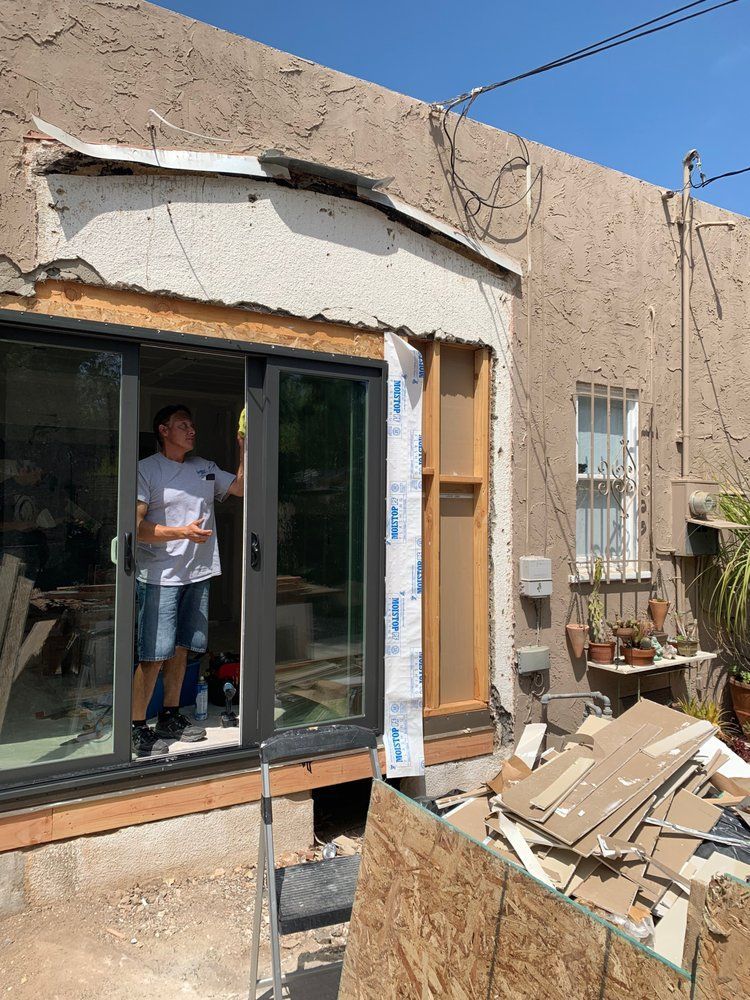A man is standing in front of a sliding glass door.