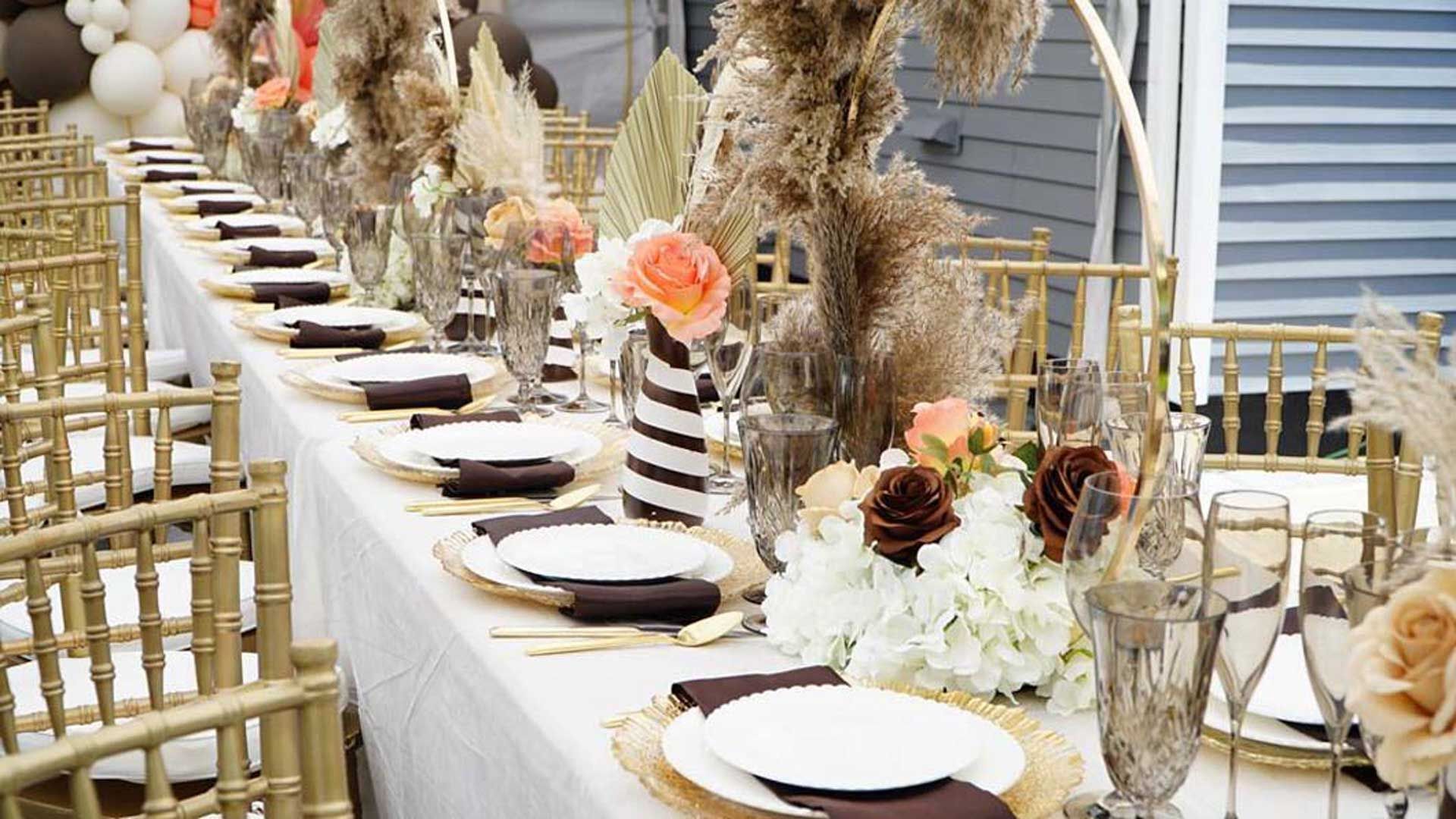 A long table with empty plates and flowers on it