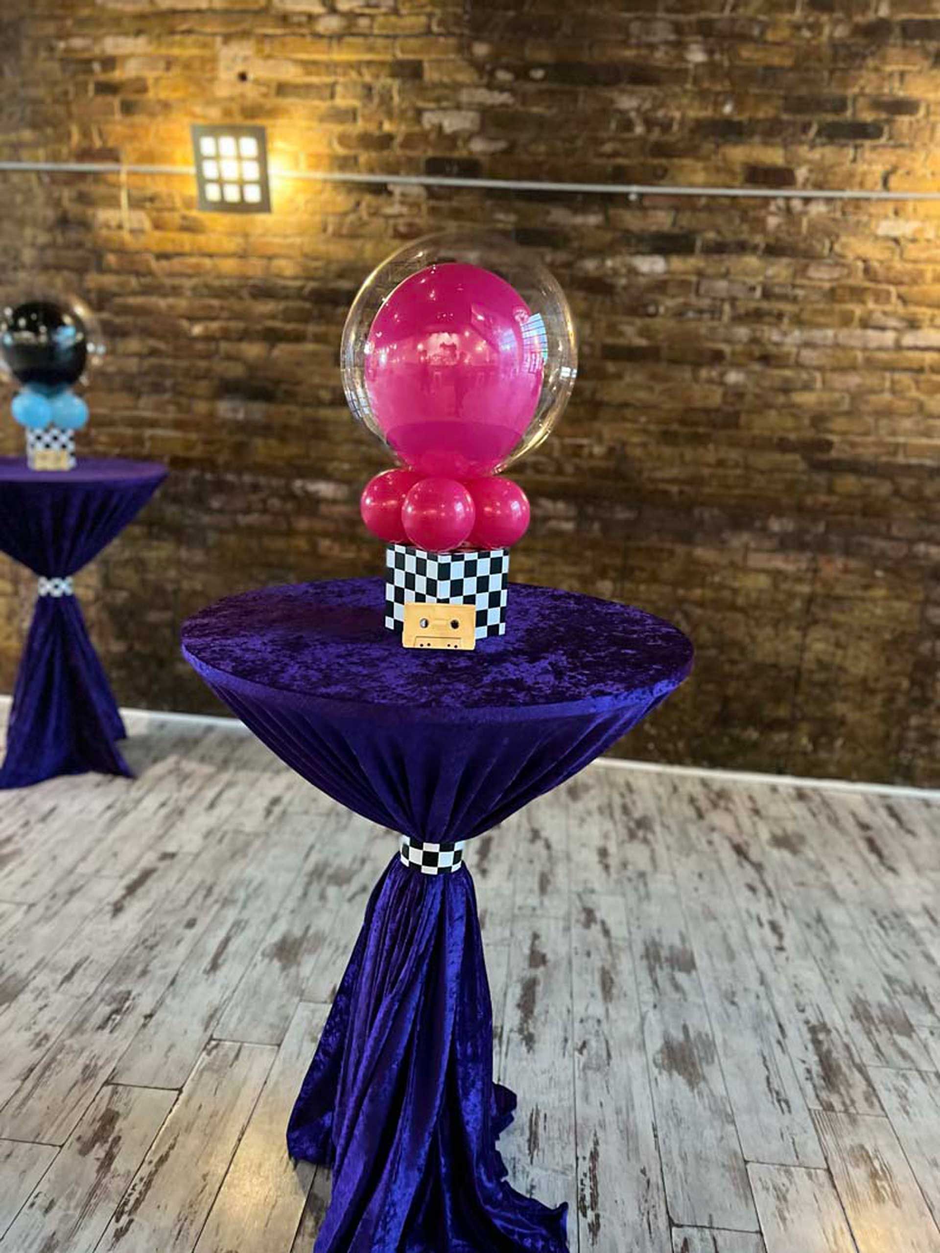 A purple table with a pink balloon on top of it