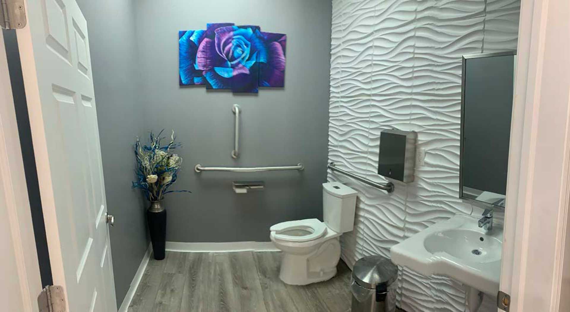 A bathroom with a toilet, sink and mirror