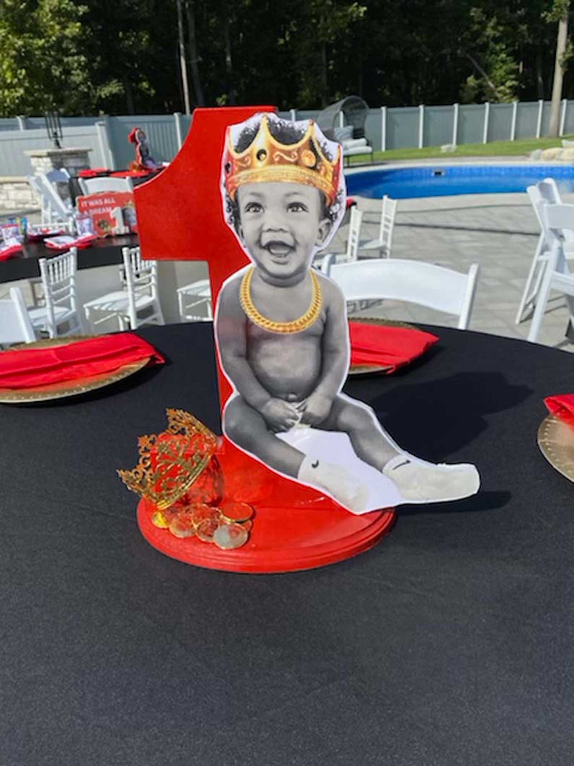 A cut out of a baby wearing a crown is sitting on a table