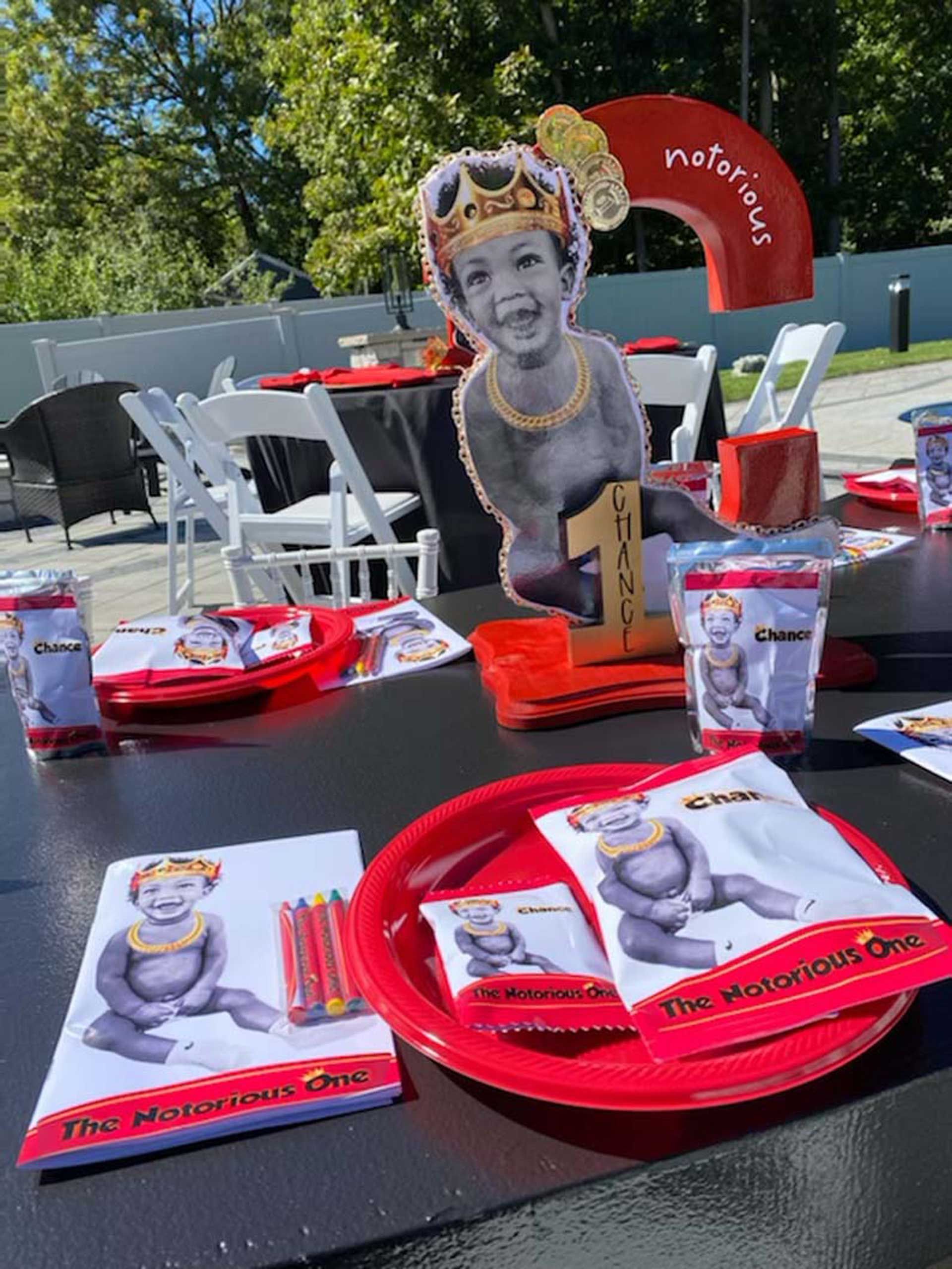 A table with plates, napkins, cups and a picture of a baby on it