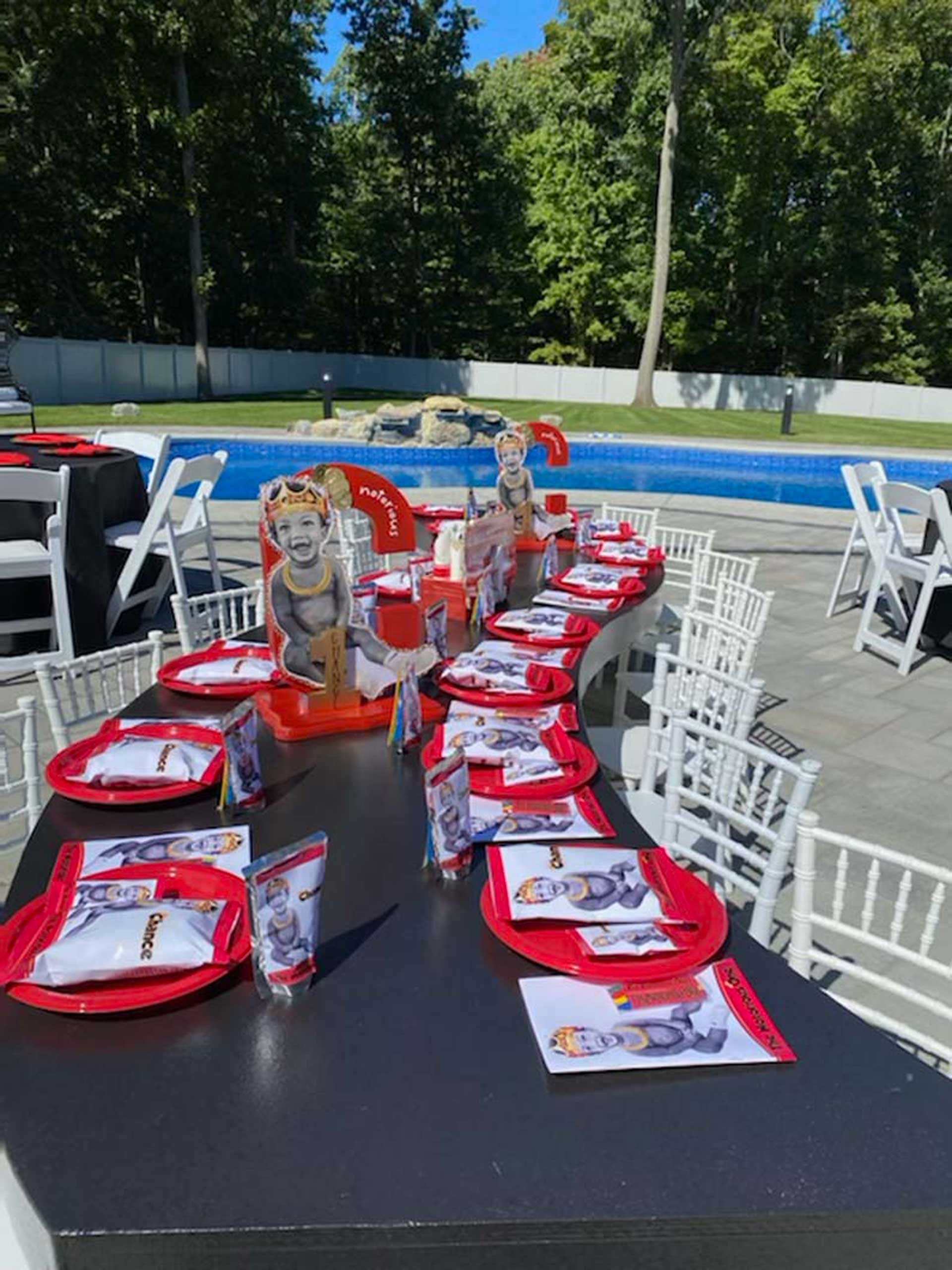 A long table with plates and napkins set up for a birthday party