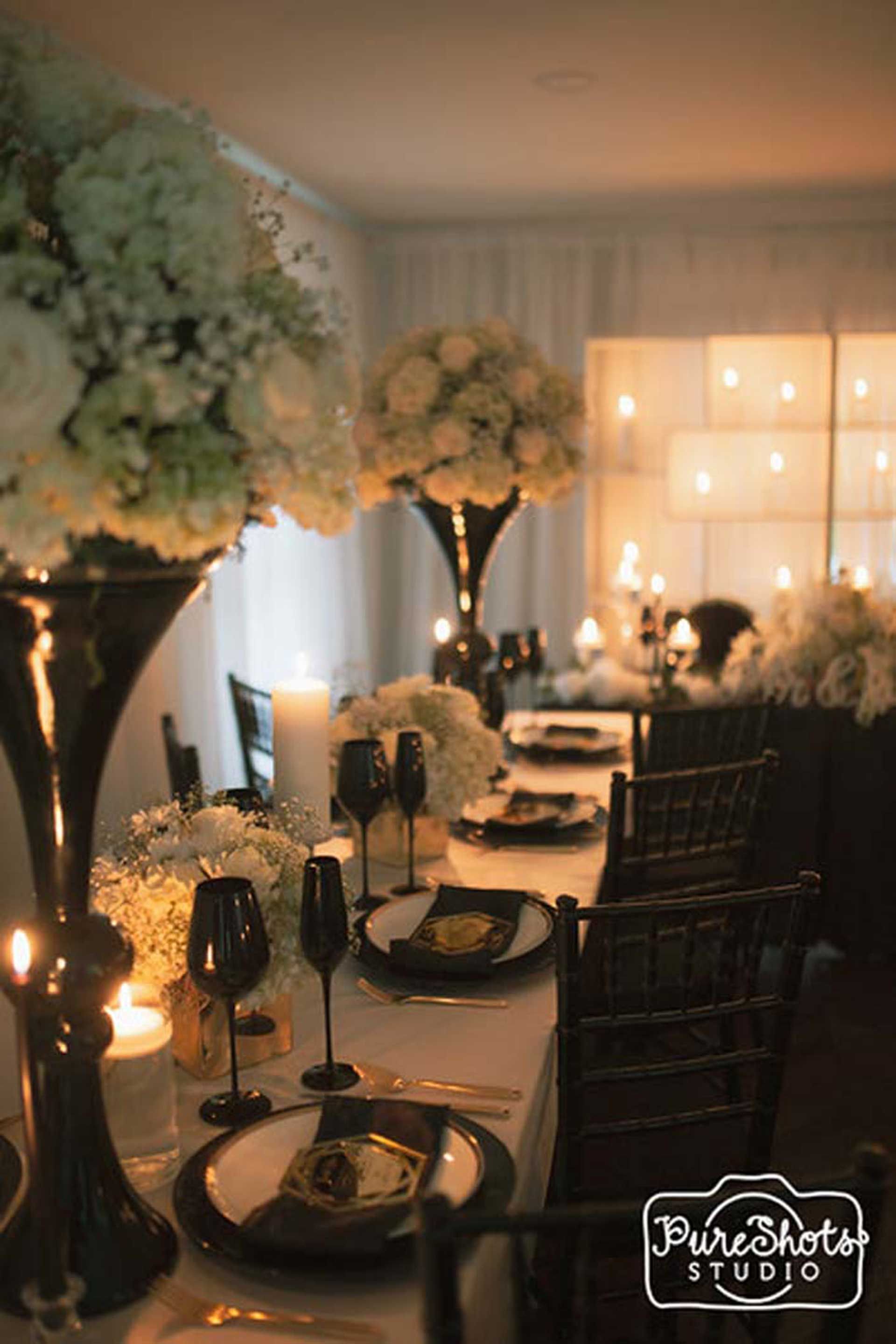 A long table with plates, candles, and flowers on it