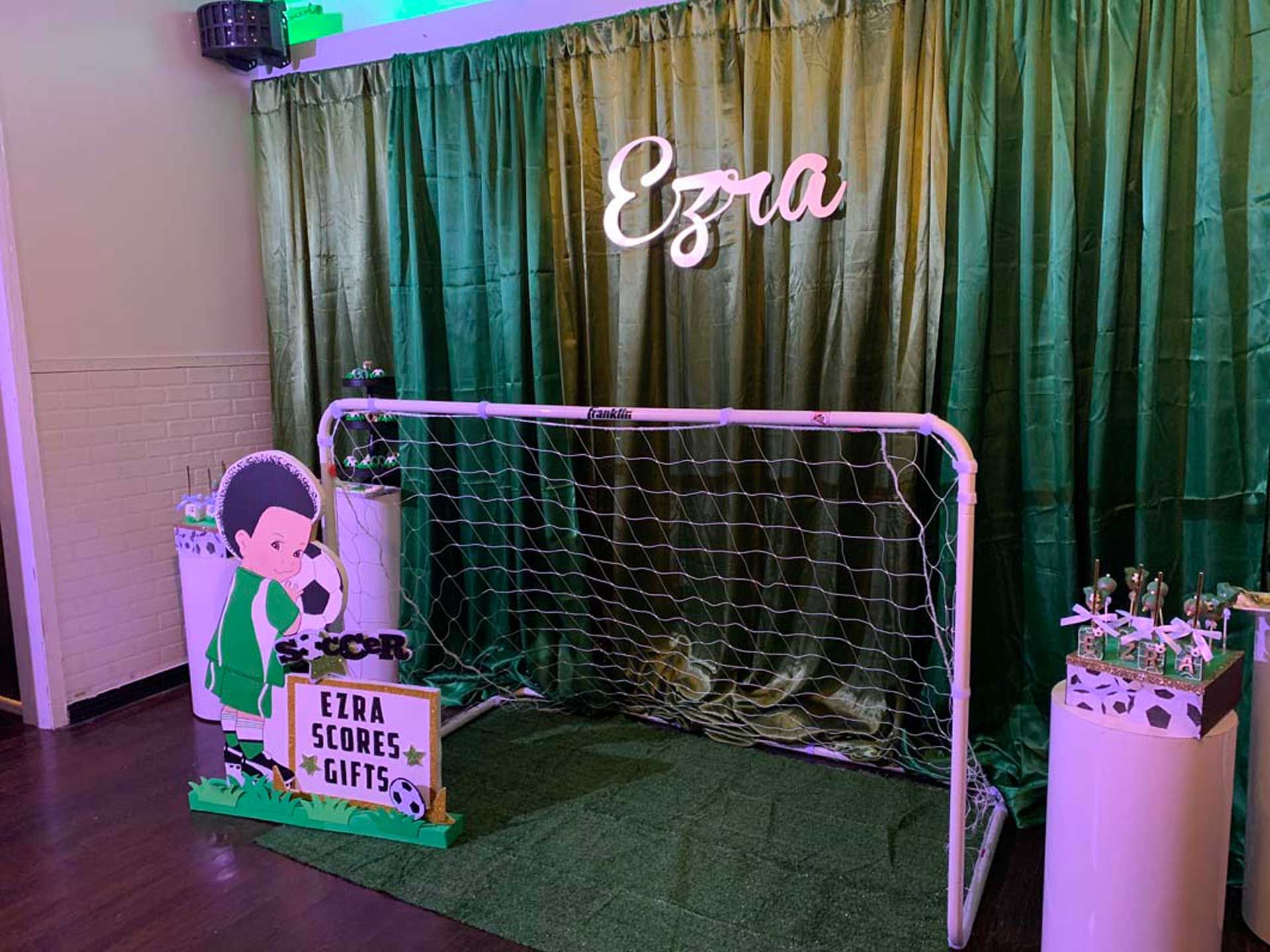 A soccer goal is sitting in front of a green curtain