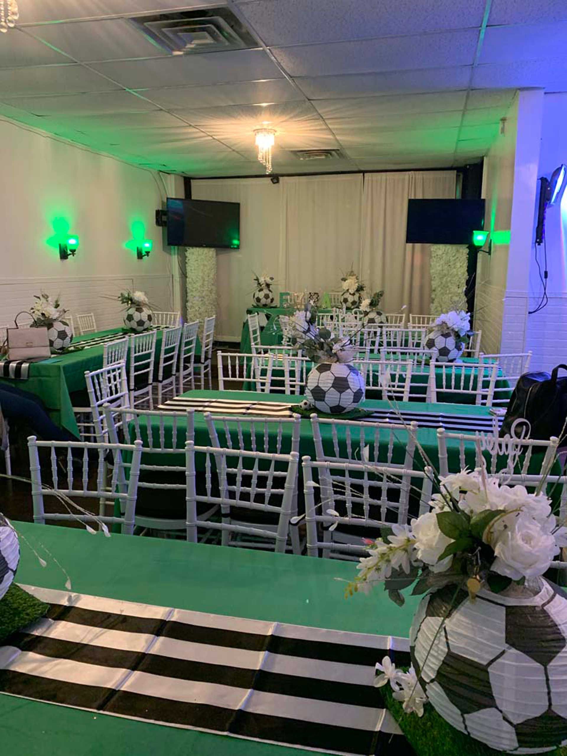A room filled with tables and chairs decorated with soccer balls and flowers