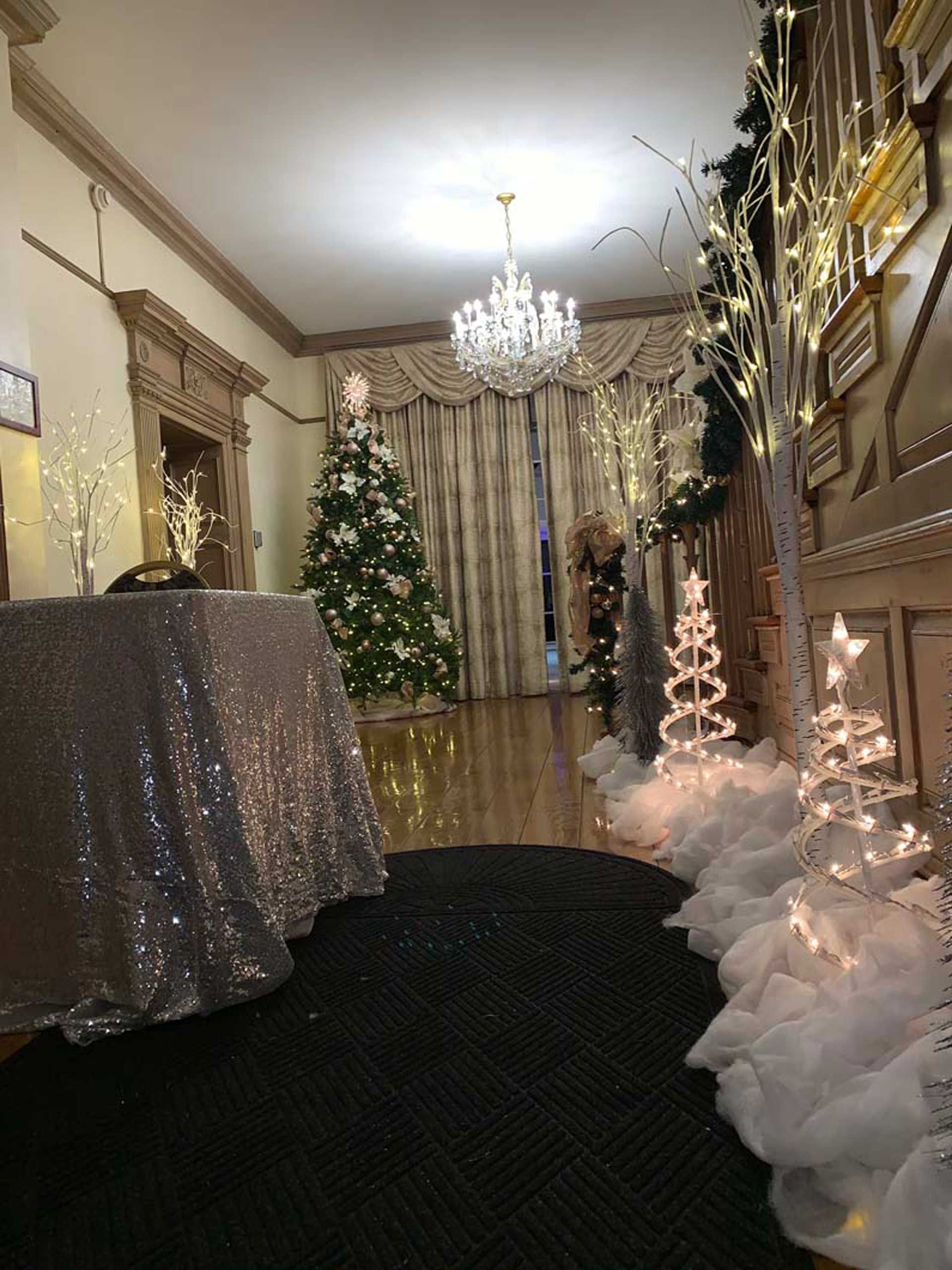 A room decorated for Christmas with a table and trees