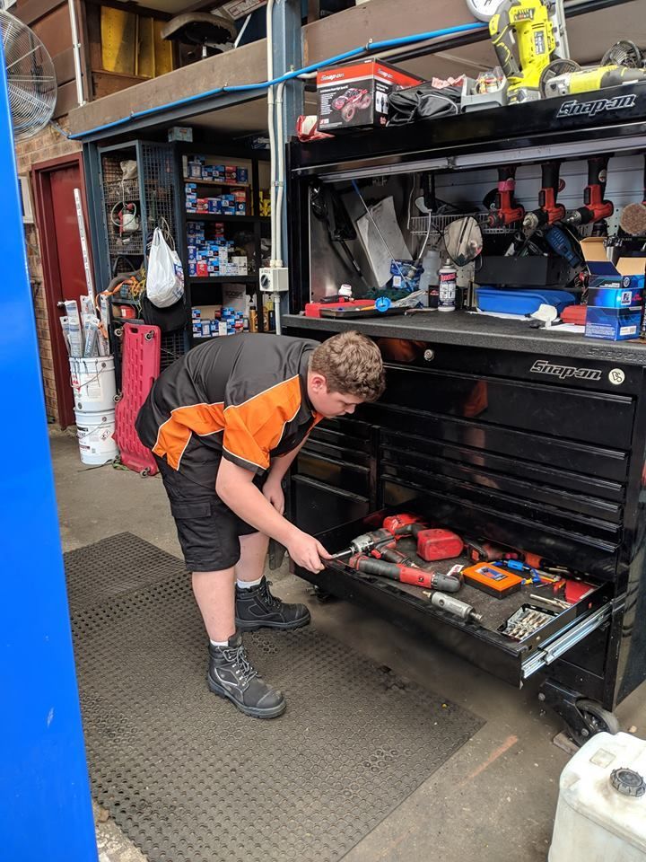 A Young Man is Working on a Toolbox in a Garage — Edgy Car Mechanics in Edgeworth, NSW