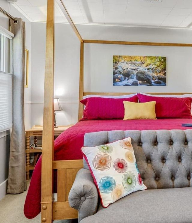 A bedroom with a four poster bed and a couch