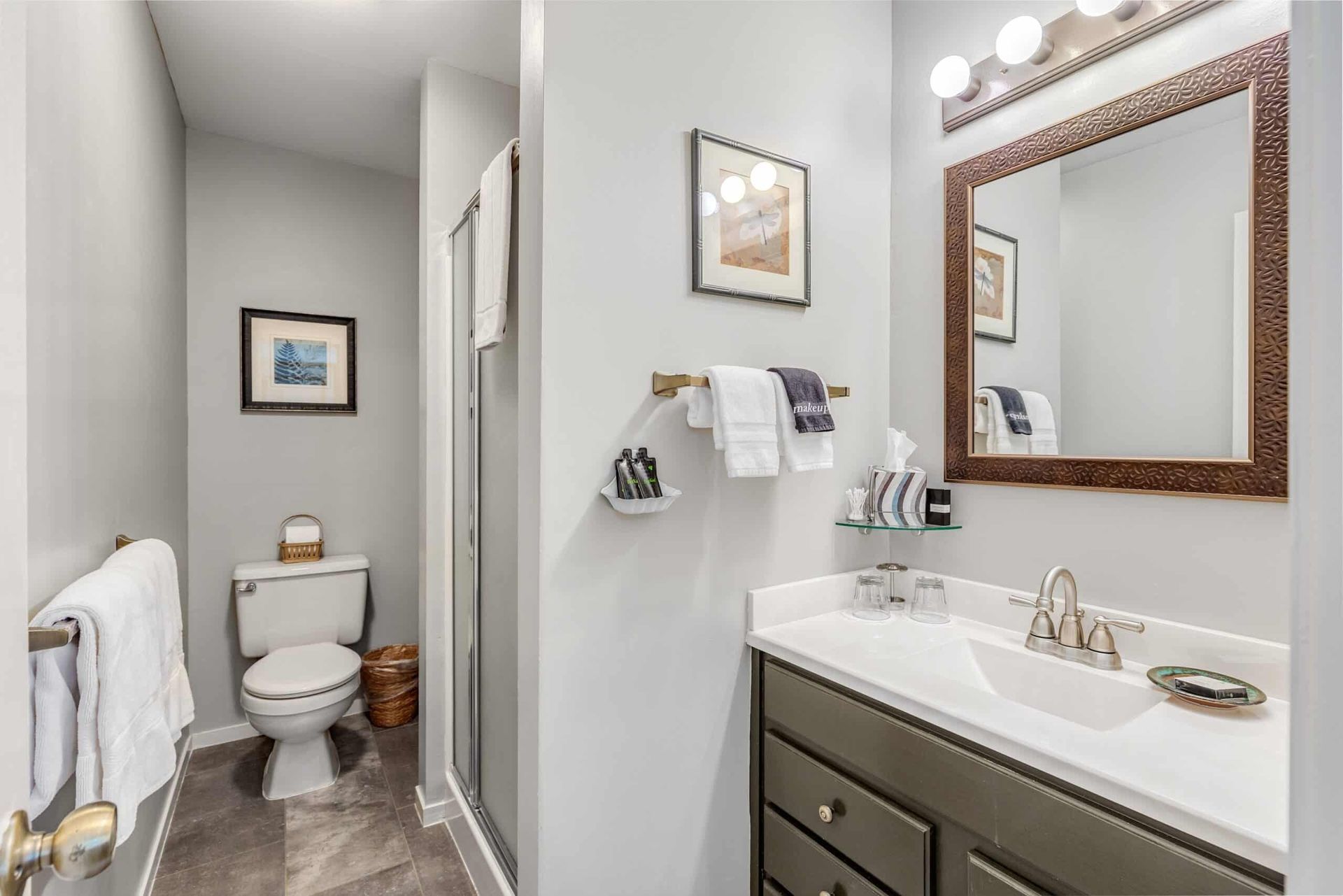 A bathroom with a toilet , sink and mirror.