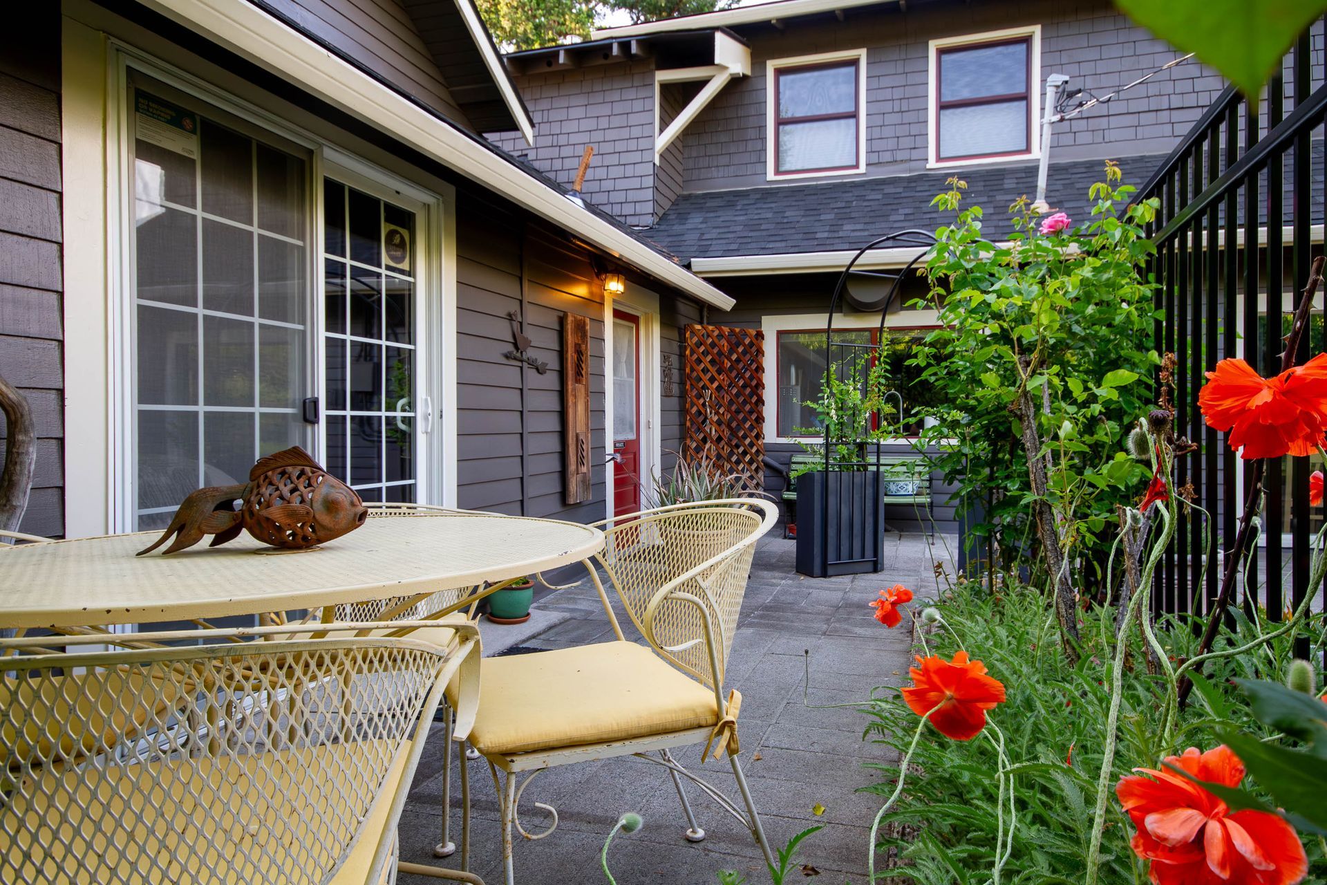 A patio with a table and chairs in front of a house